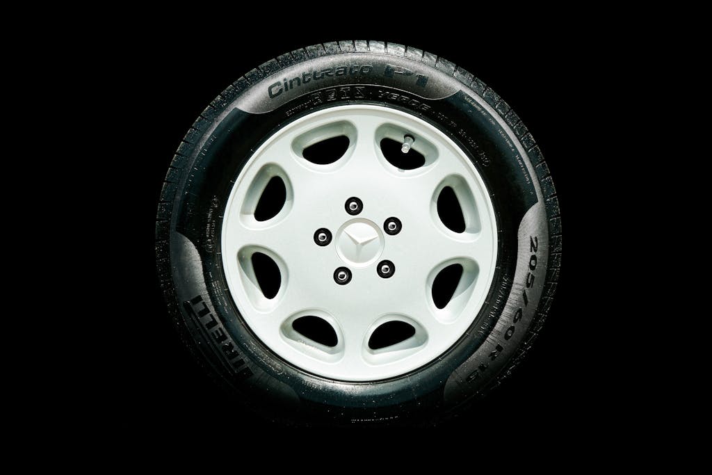 Detailed close-up of a Mercedes alloy wheel with Pirelli tire on a black background.