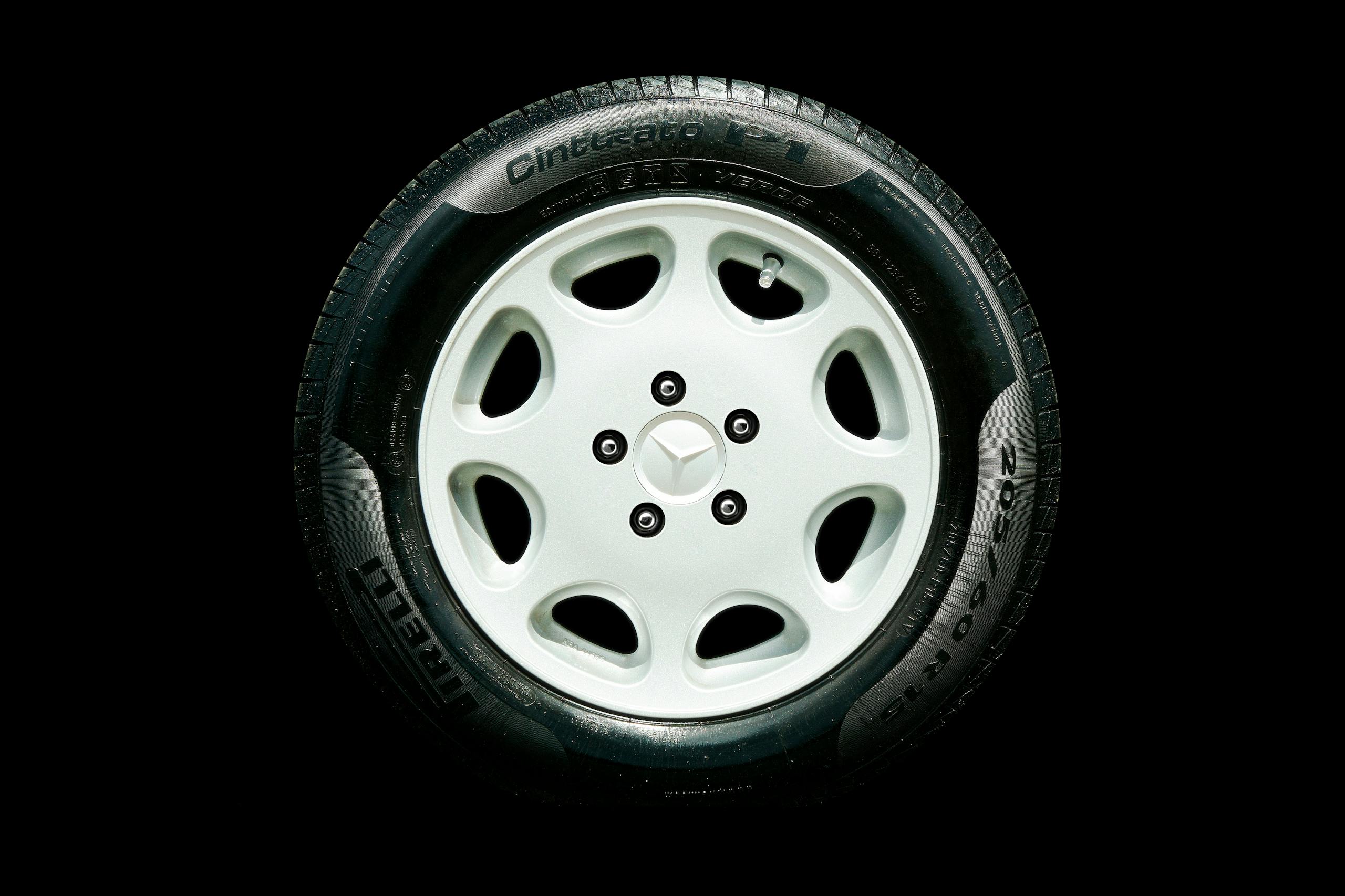 Detailed close-up of a Mercedes alloy wheel with Pirelli tire on a black background.