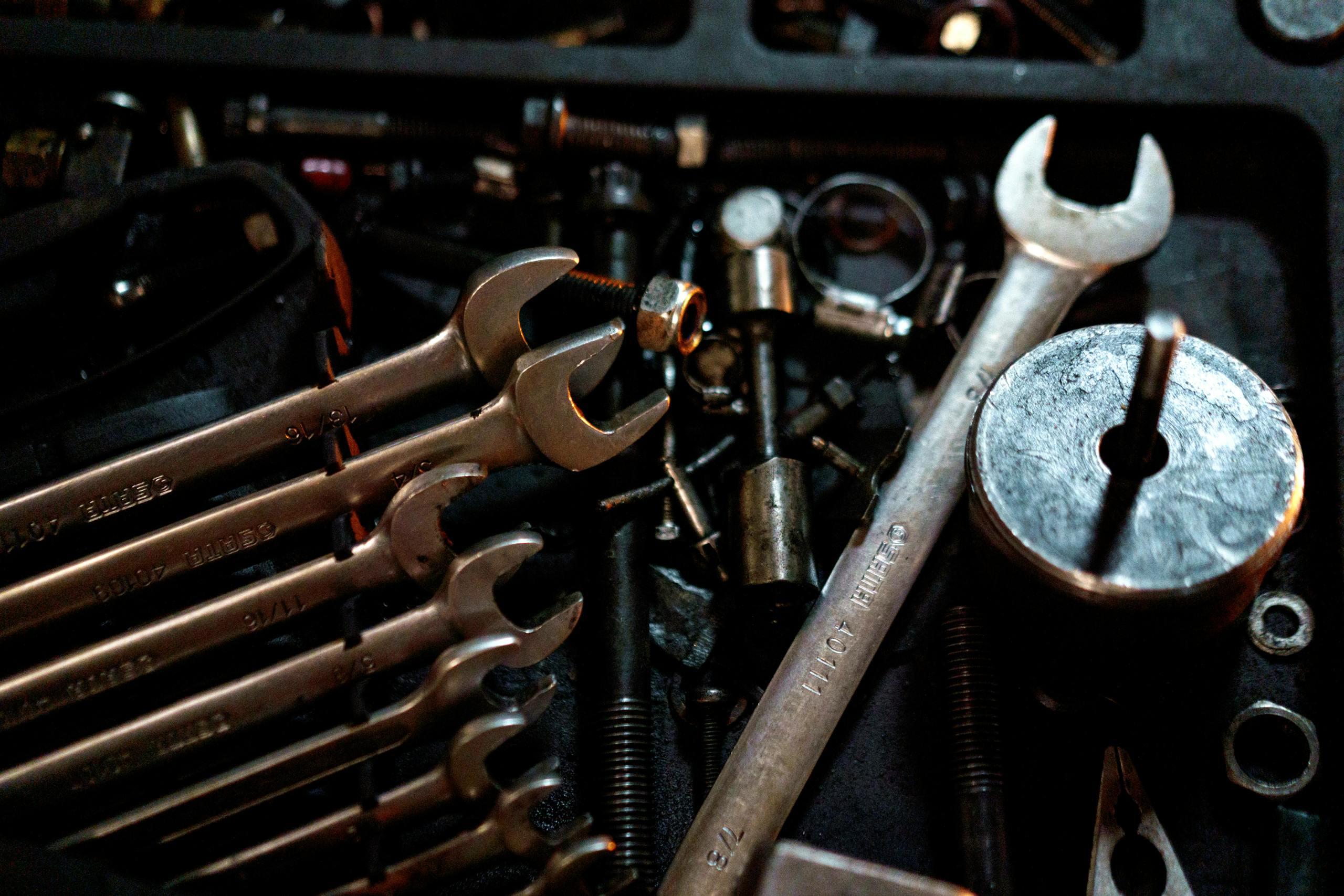 Detailed view of scattered wrenches and metal parts, showcasing an array of tools for mechanical purposes.